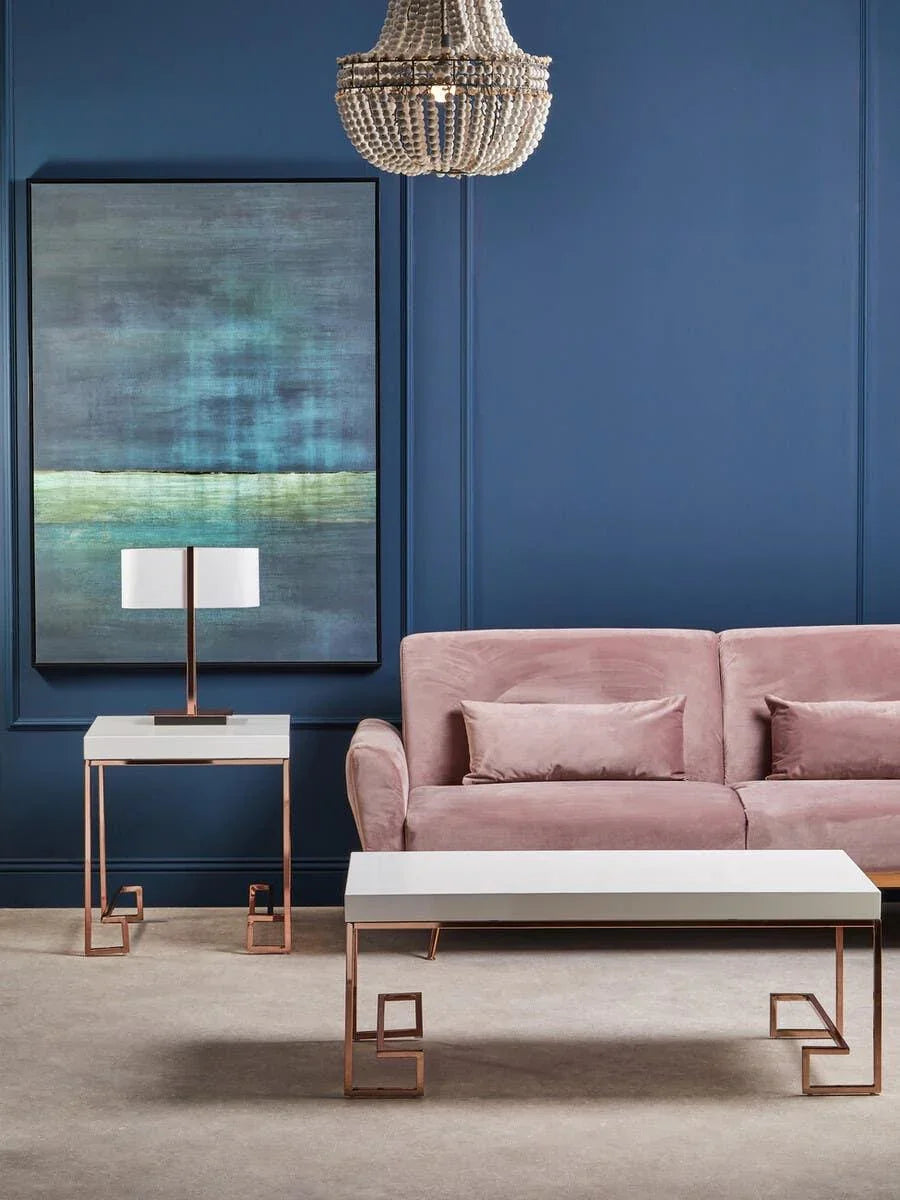 Blush pink velvet sofa with white and rose gold coffee and side tables in modern living room
