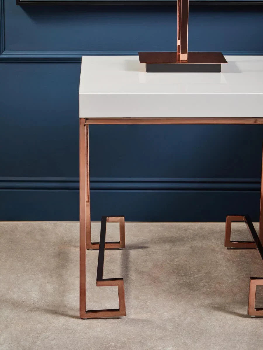 White gloss console table with rose gold metal legs against a blue wall