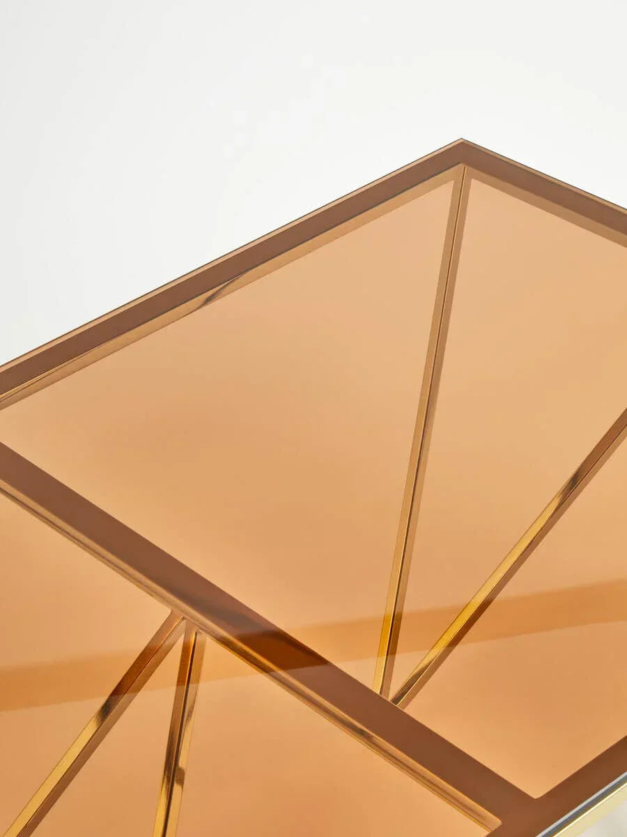 Close-up of gold glass coffee table with geometric metal frame detail