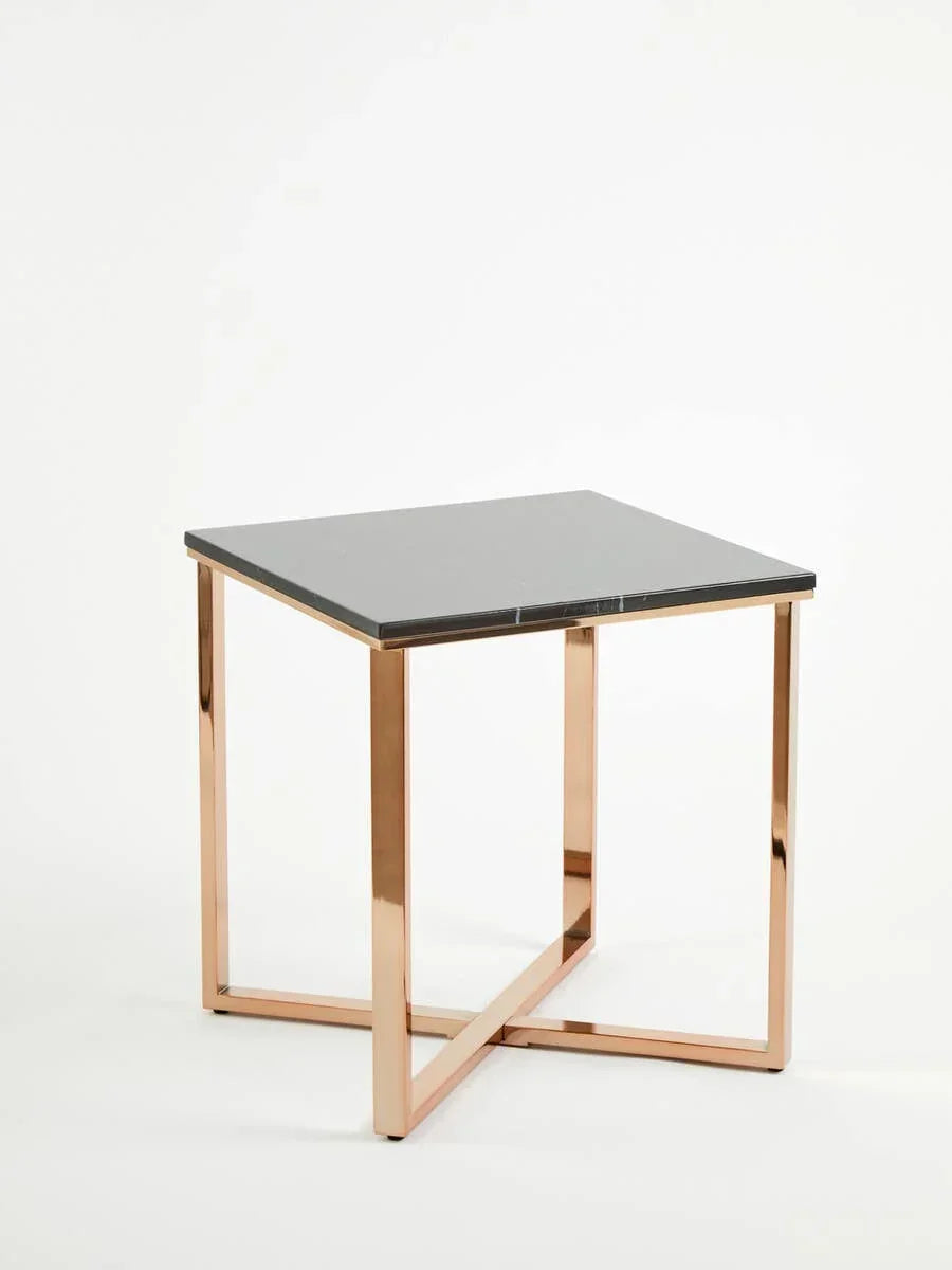 Square side table with black glass top and gold metal frame on white background
