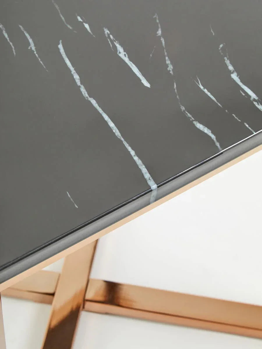 Black marble dining table with gold metal legs, close-up on veined tabletop corner