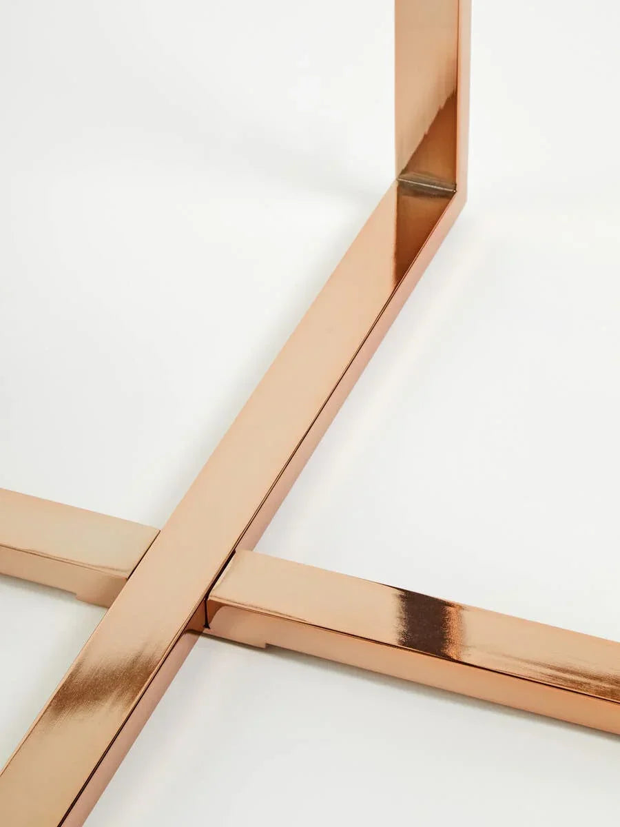 Rose gold metal table legs with modern cross frame on white background
