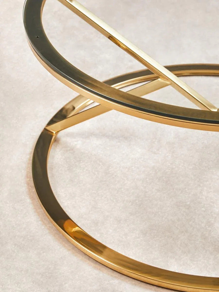 Gold metal coffee table base with circular design on light carpet