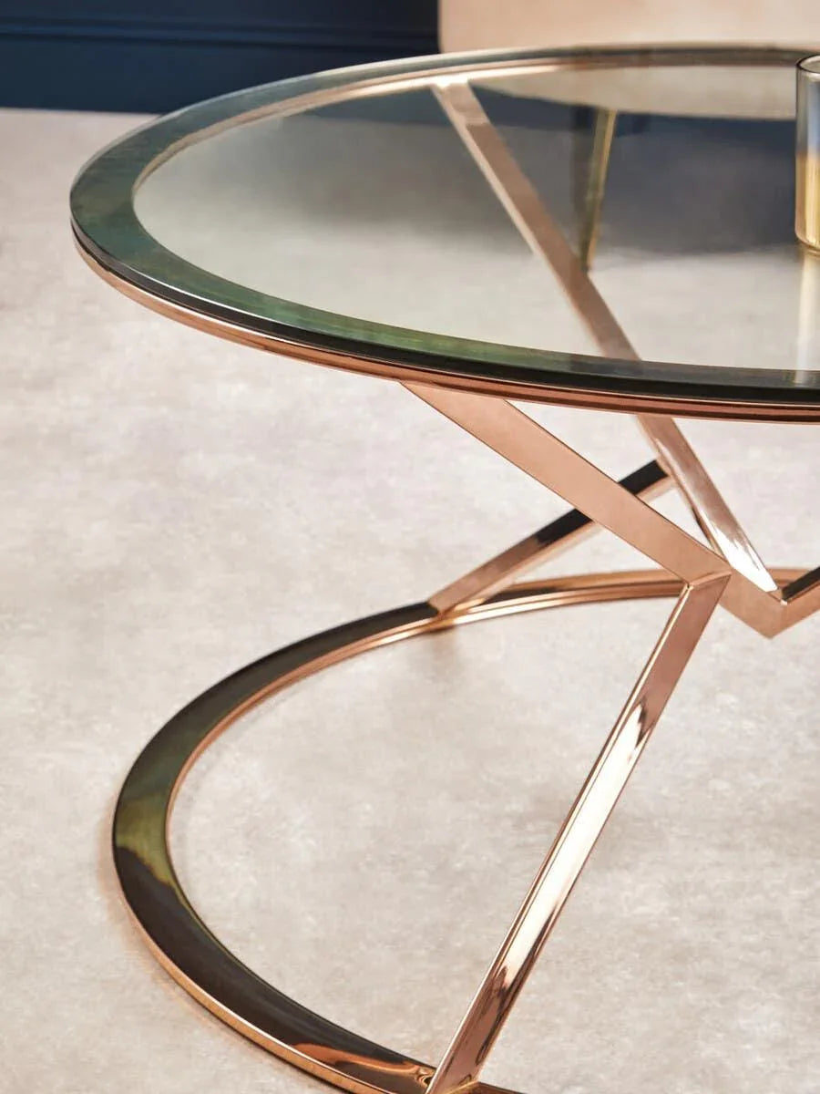 Glass top coffee table with rose gold metal frame on beige carpet