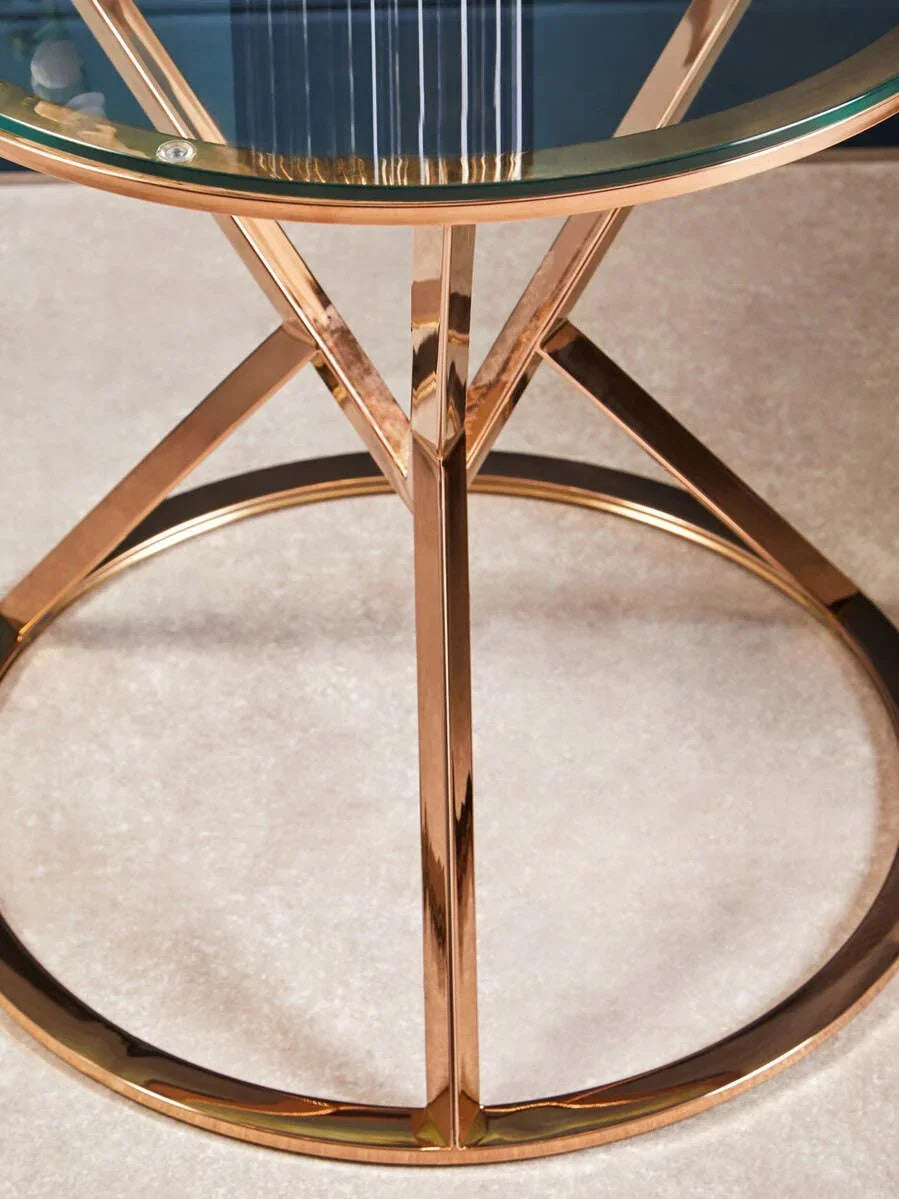 Round glass top coffee table with gold metal frame on beige carpet