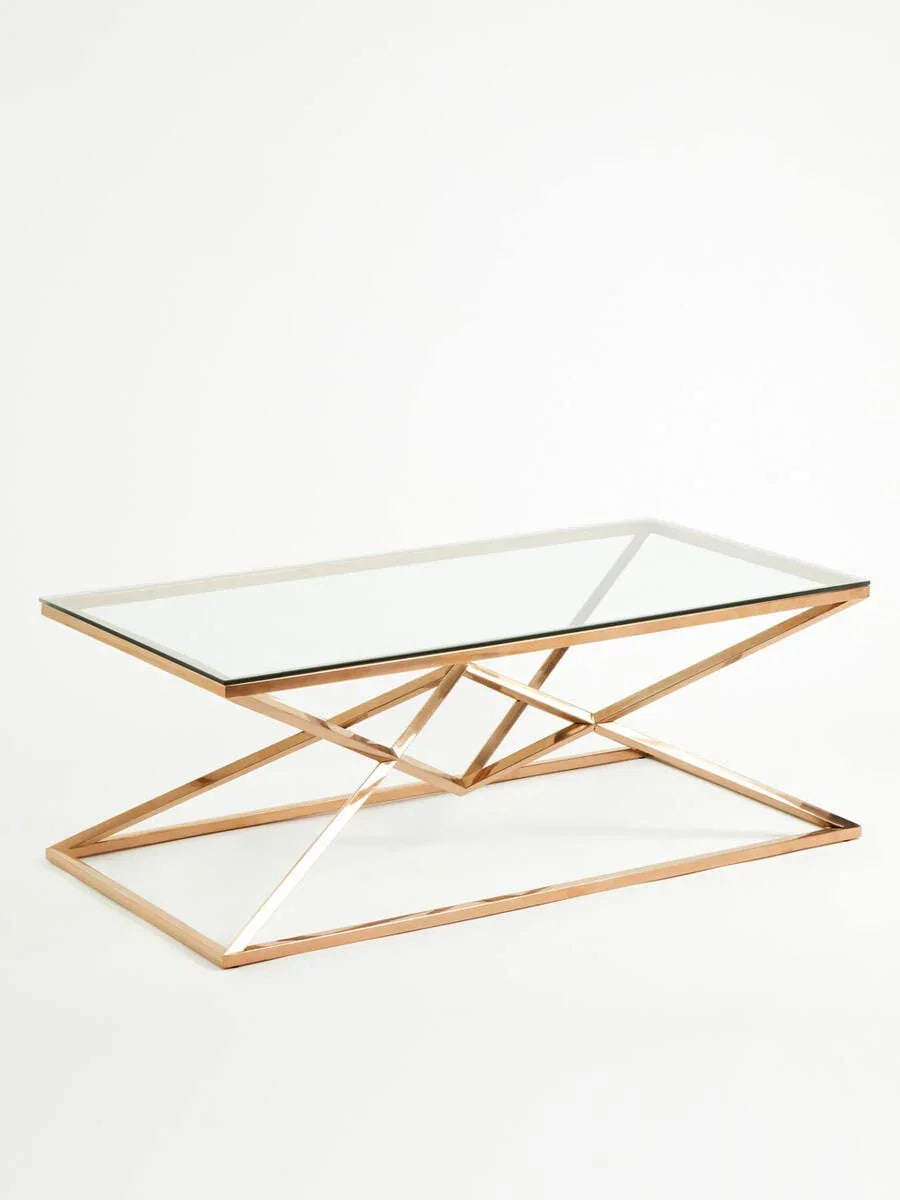 Glass coffee table with geometric gold metal base on white background