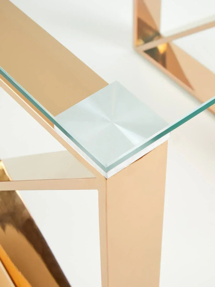 Close-up of gold metal and glass coffee table corner with modern geometric design