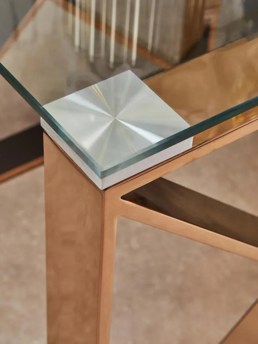 Glass dining table corner with gold metal frame and brushed steel accent