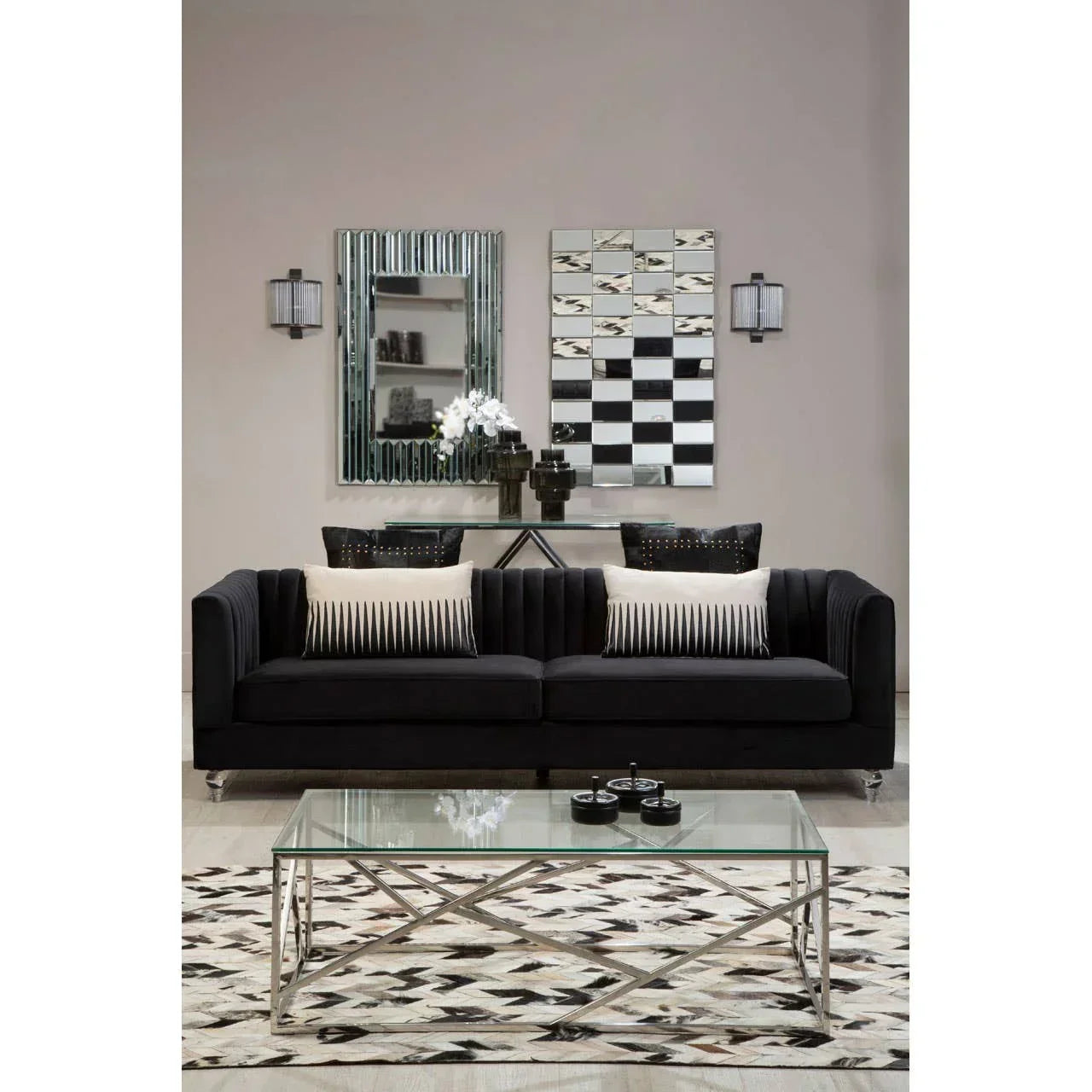 Black velvet sofa with striped cushions, glass coffee table, geometric rug in modern living room