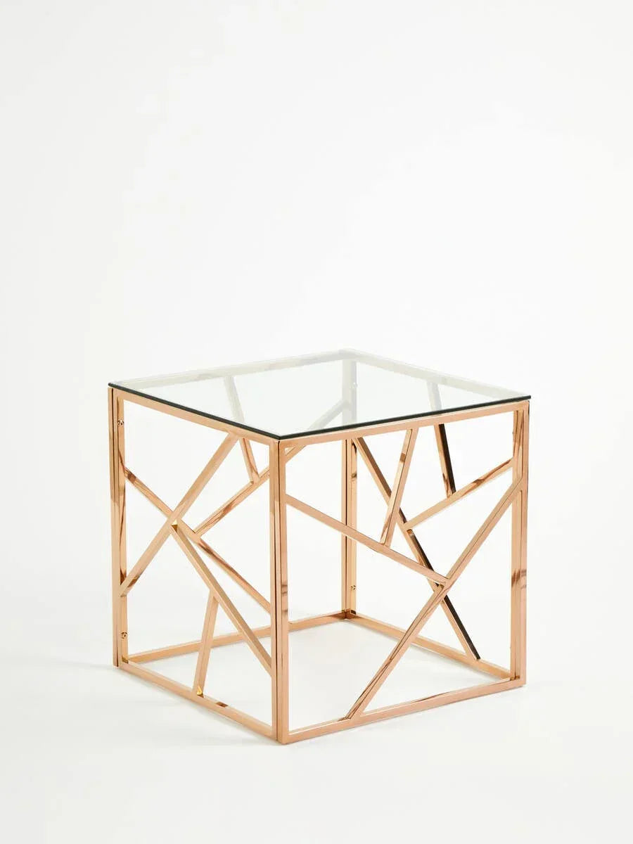 Rose gold metal and glass side table with geometric frame, shown at an angle on white background