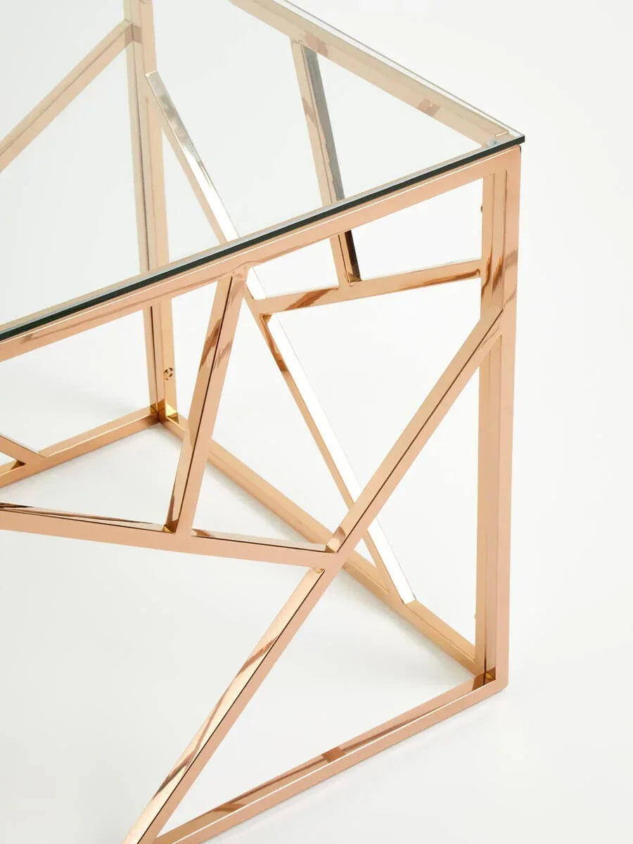 Glass top table with geometric gold metal frame, corner detail view