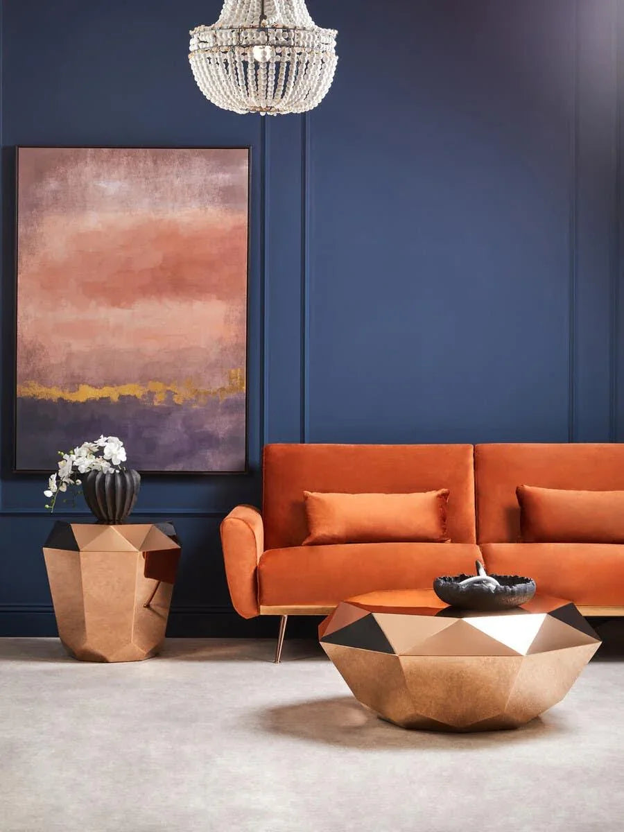 Orange velvet sofa with gold geometric coffee table in modern living room setting