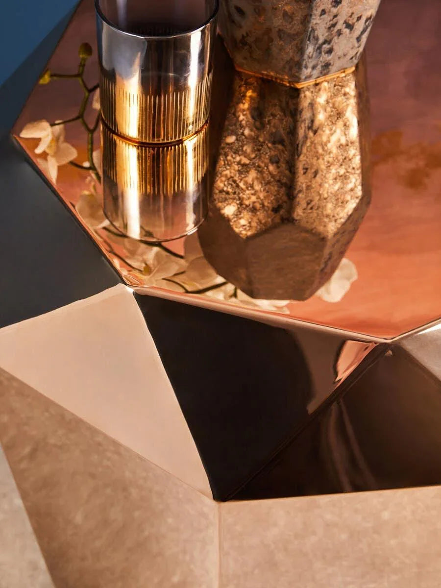 Geometric metallic coffee table with gold decor accents and natural stone vase detail