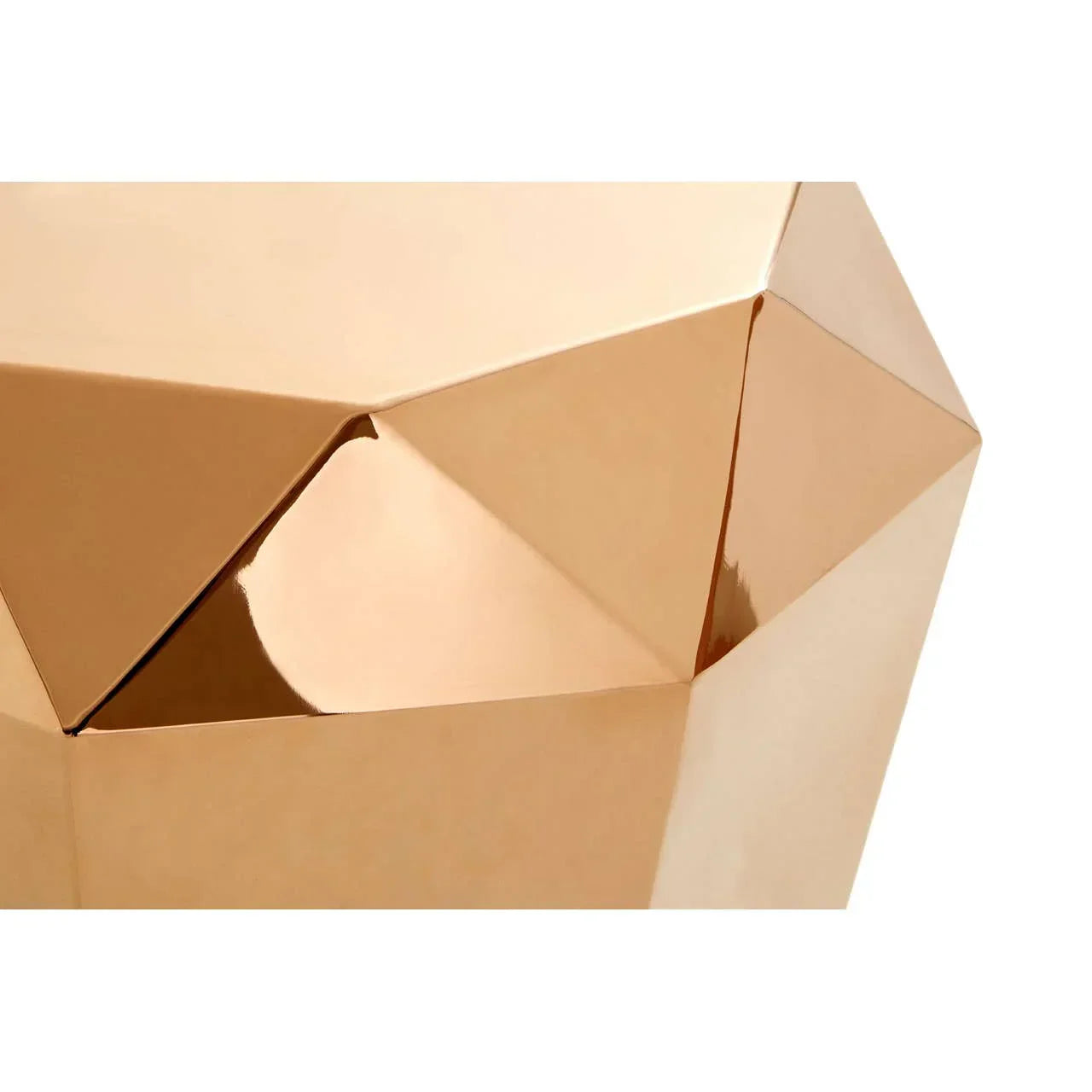 Geometric gold metal coffee table with faceted angular surface close-up