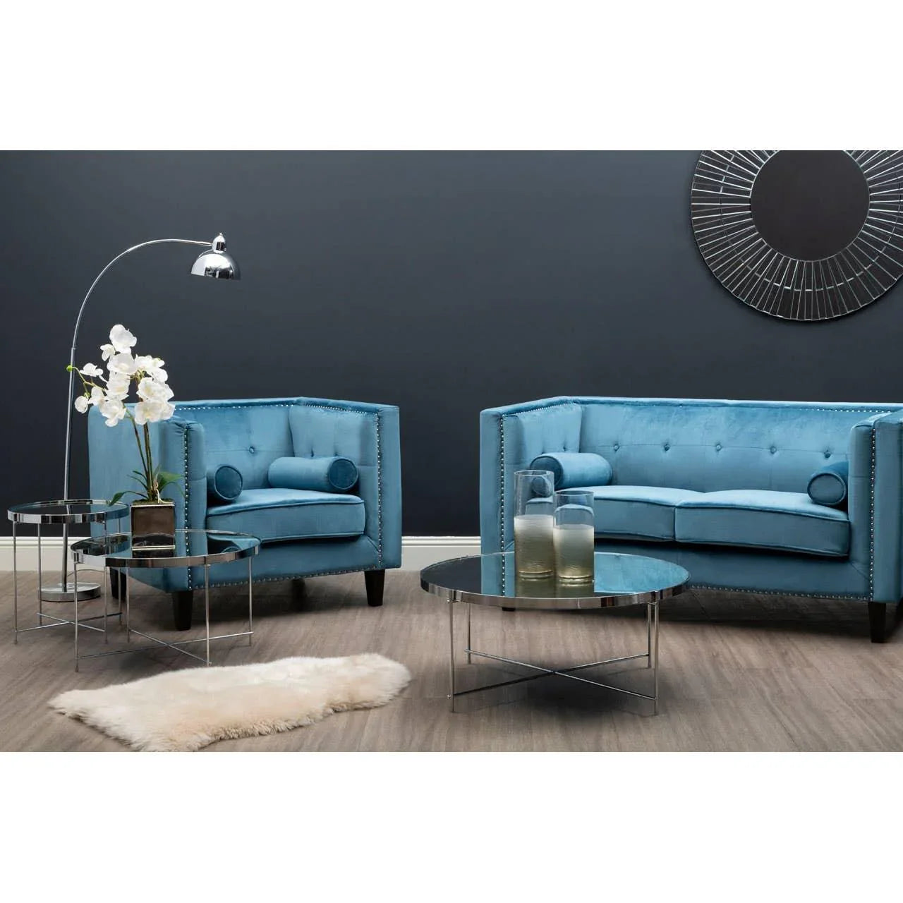 Blue velvet sofa set with chrome coffee tables and modern decor in stylish living room
