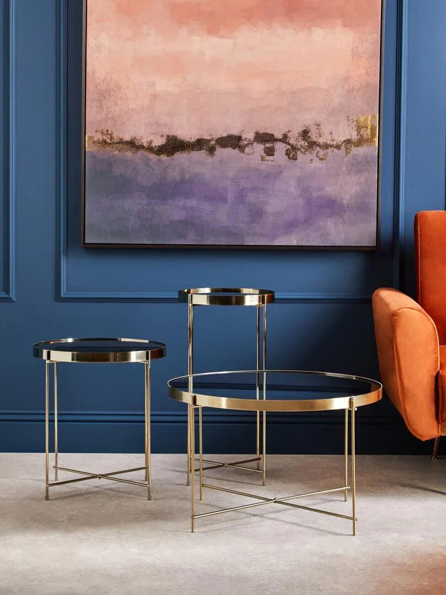 Gold and glass nest of tables set with round tops in modern living room