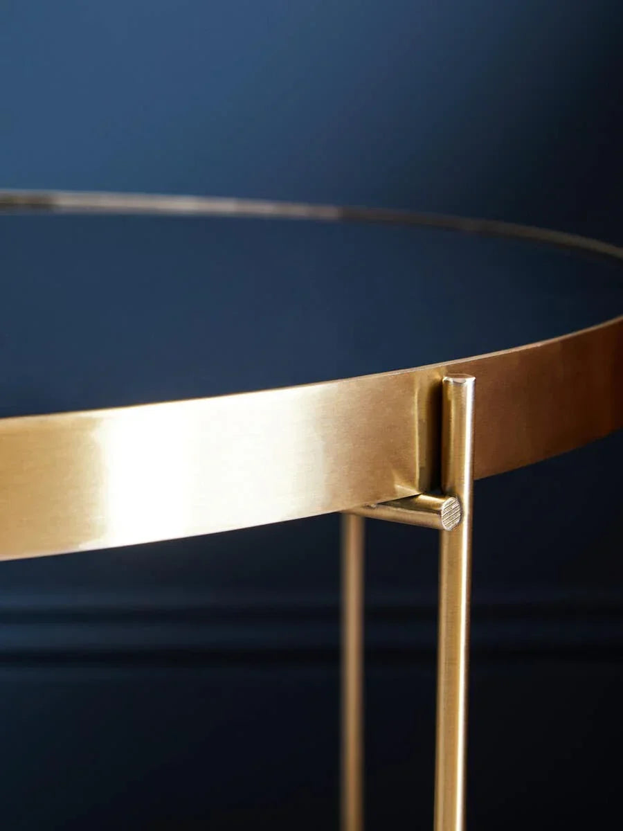 Brushed gold metal round table edge with modern frame against dark background