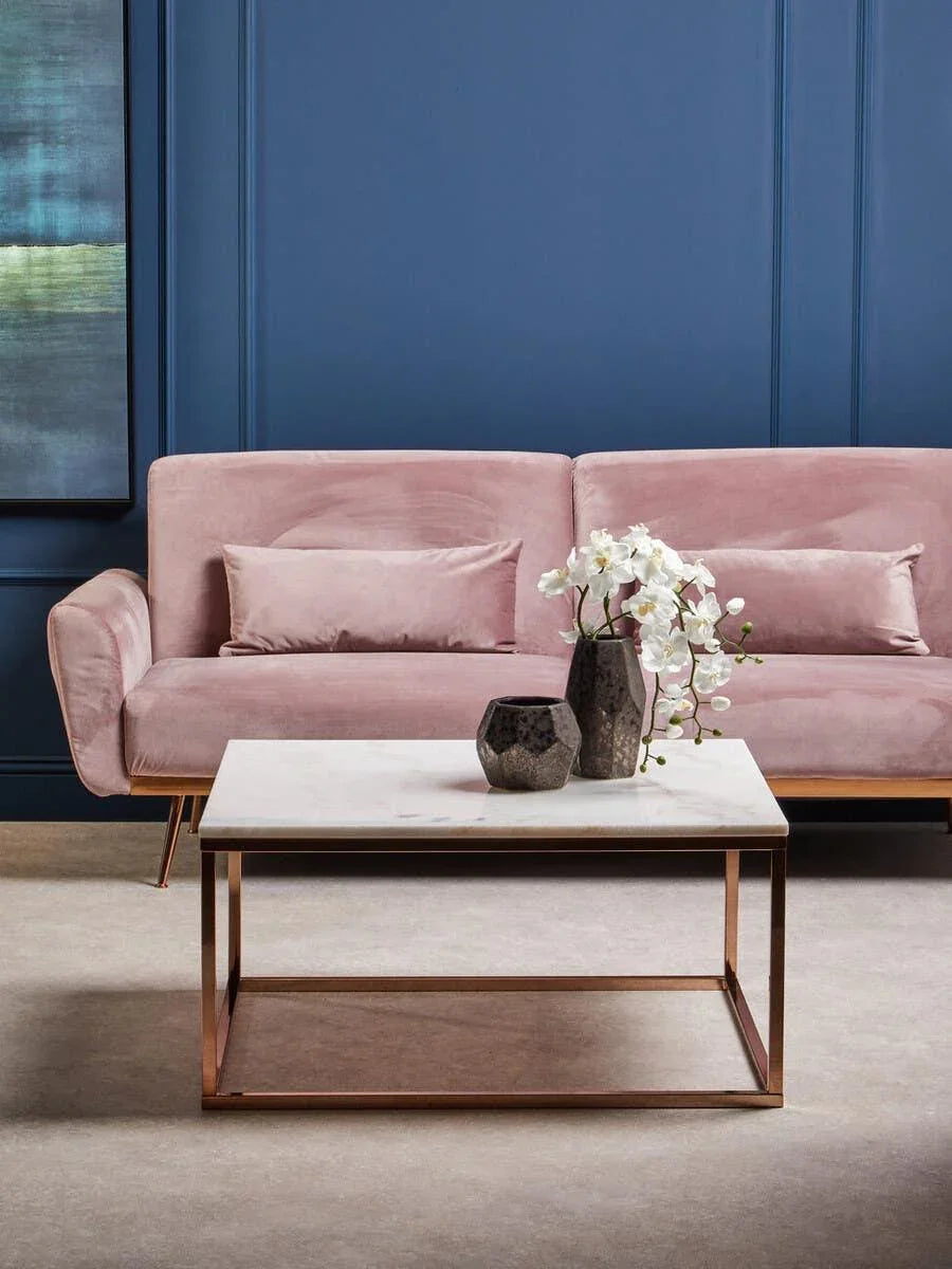 Velvet pink sofa with matching cushions and marble top coffee table in modern living room