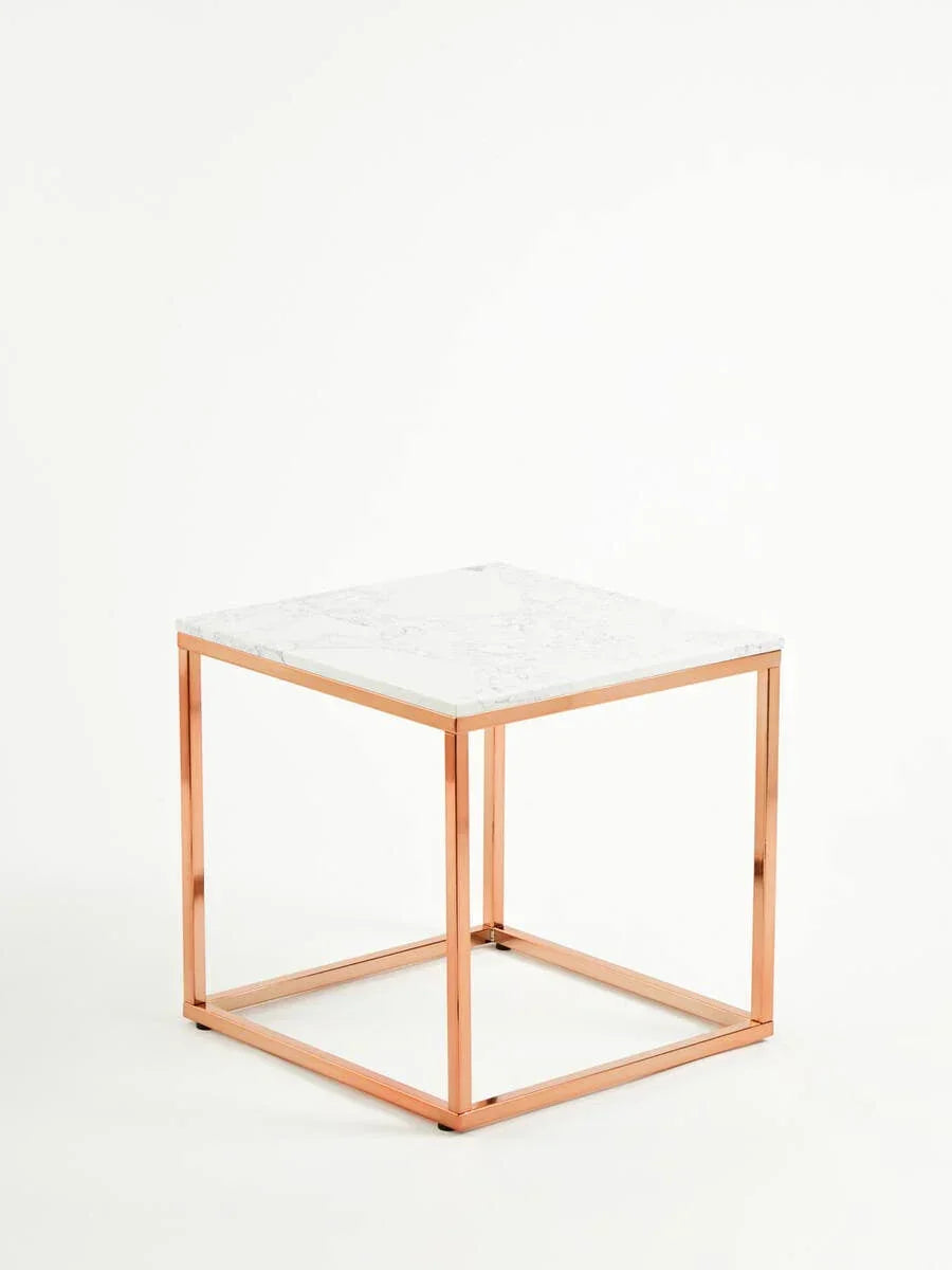 Marble top side table with rose gold metal frame on white background