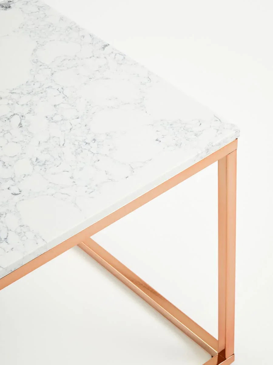 Marble dining table with white veined top and gold metal legs, close-up corner view