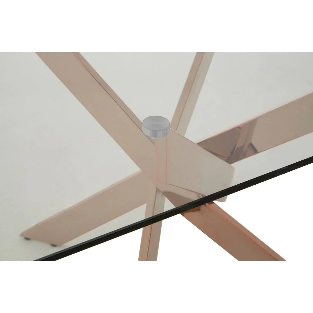 Glass dining table with rose gold crossed metal legs, close-up of corner detail