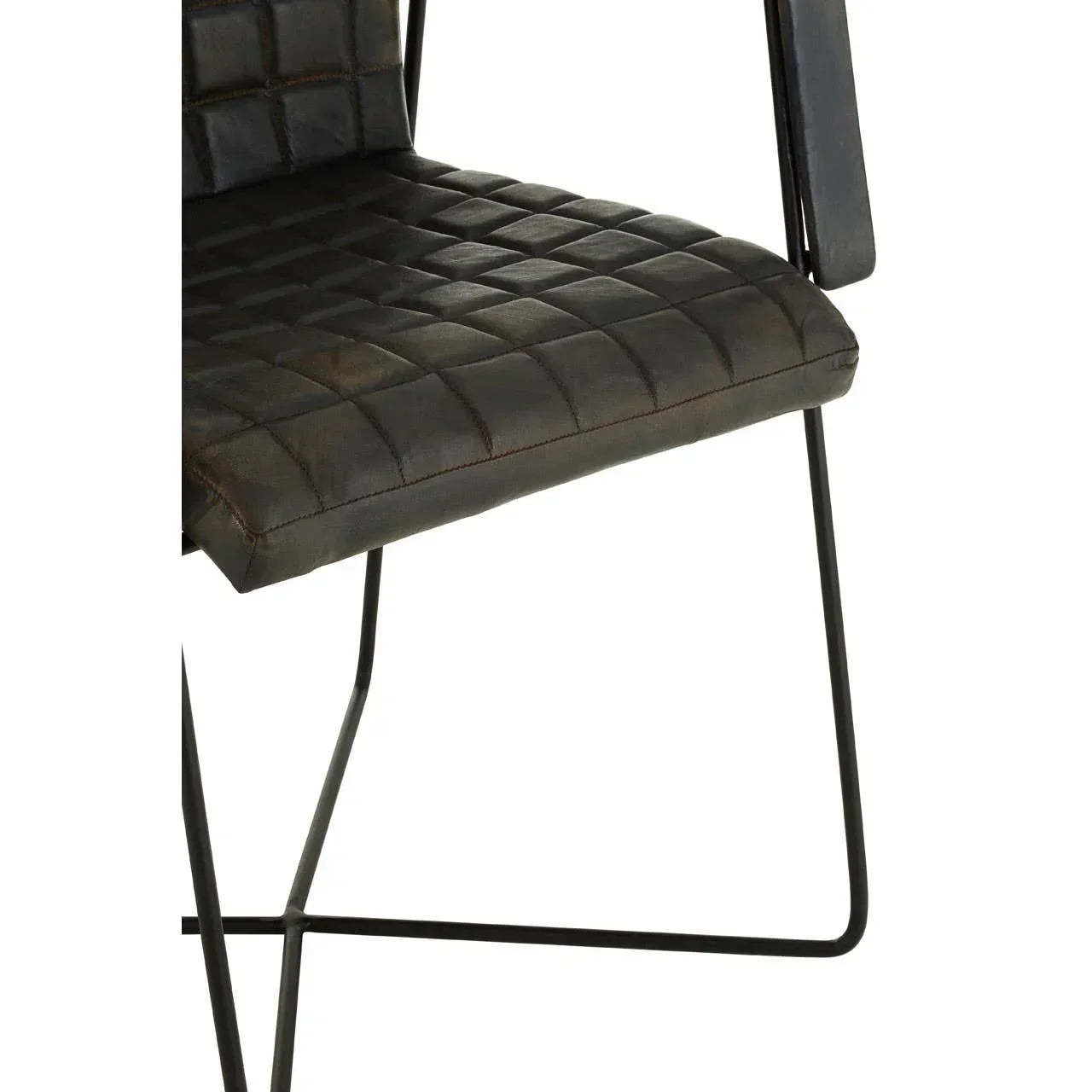 Quilted brown leather dining chair seat and black metal legs close-up