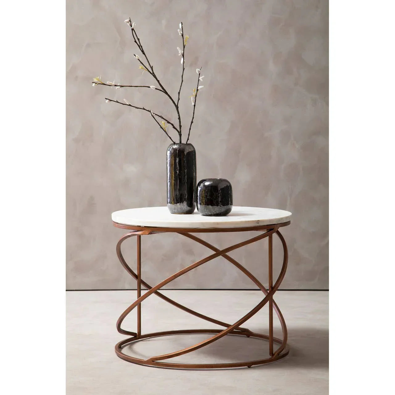 Round marble top coffee table with bronze geometric metal base, two black vases on top