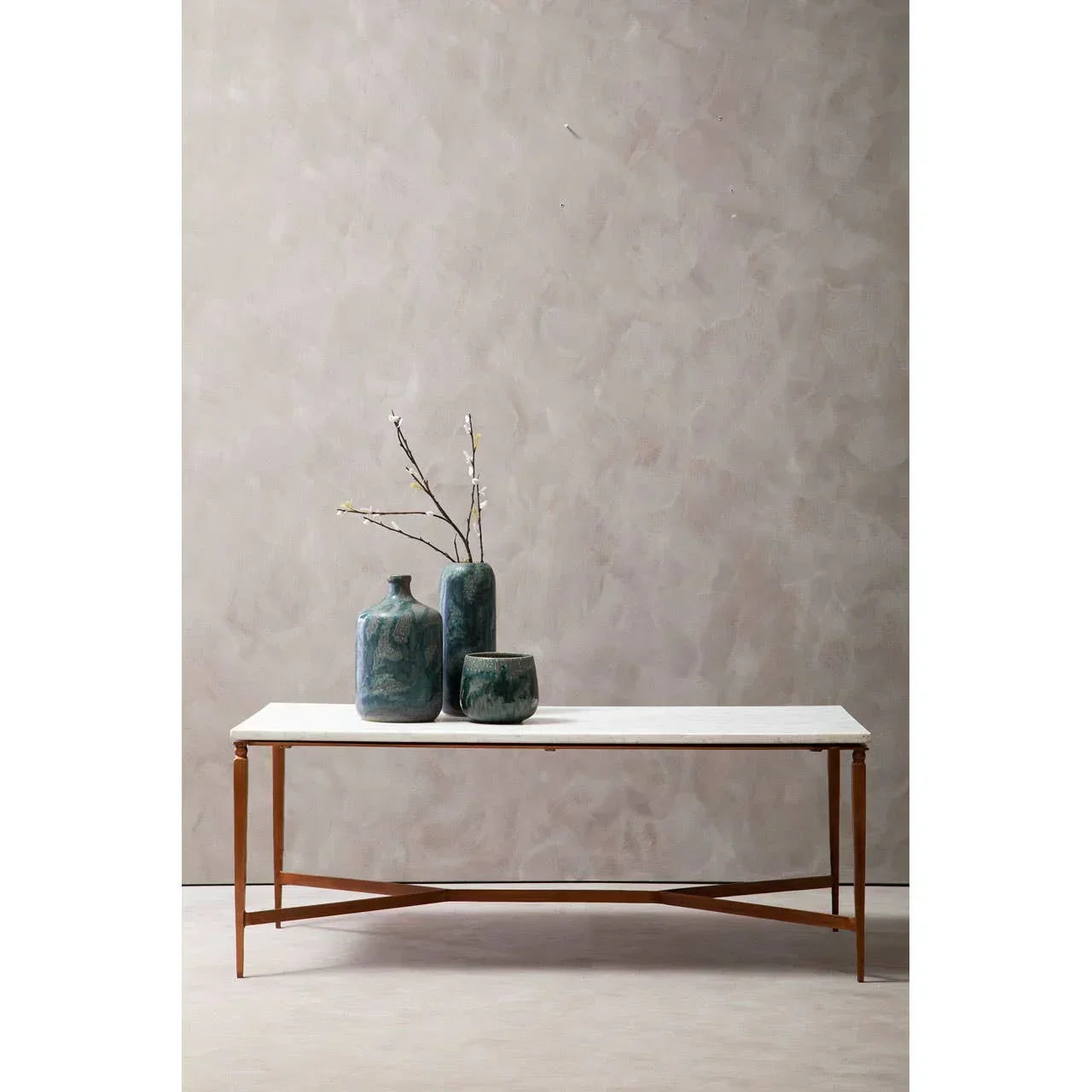 marble top coffee table with gold metal frame styled with green ceramic vases