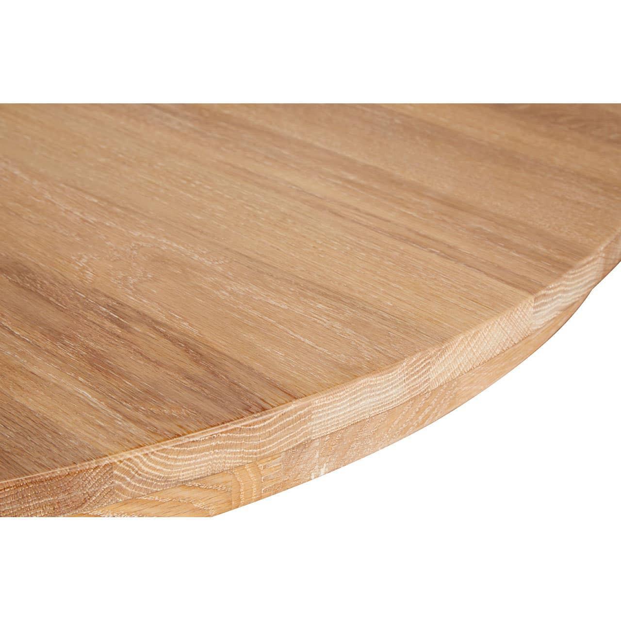 Closeup of round wooden dining table top with natural wood grain finish