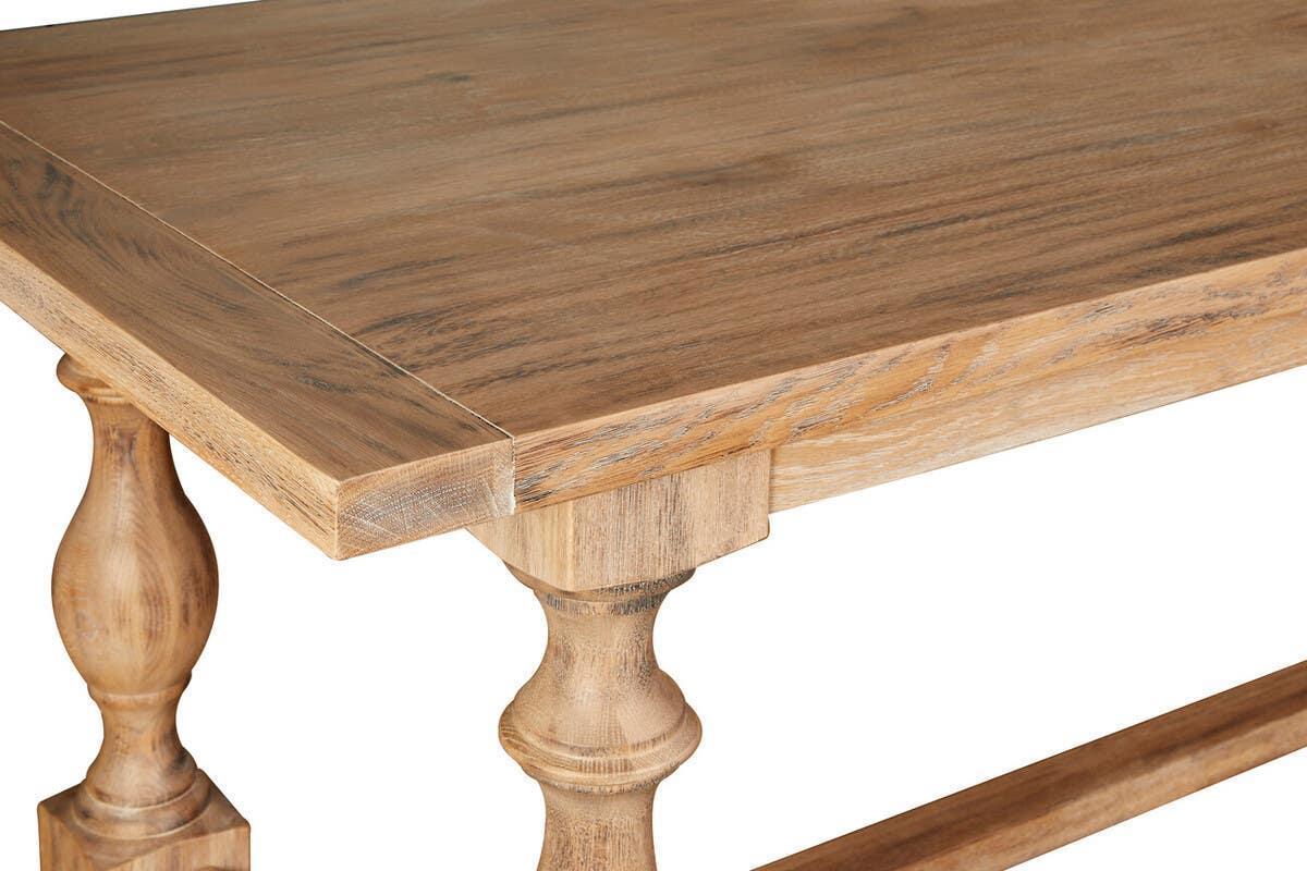 Solid wood dining table with turned legs and natural oak finish, close corner view