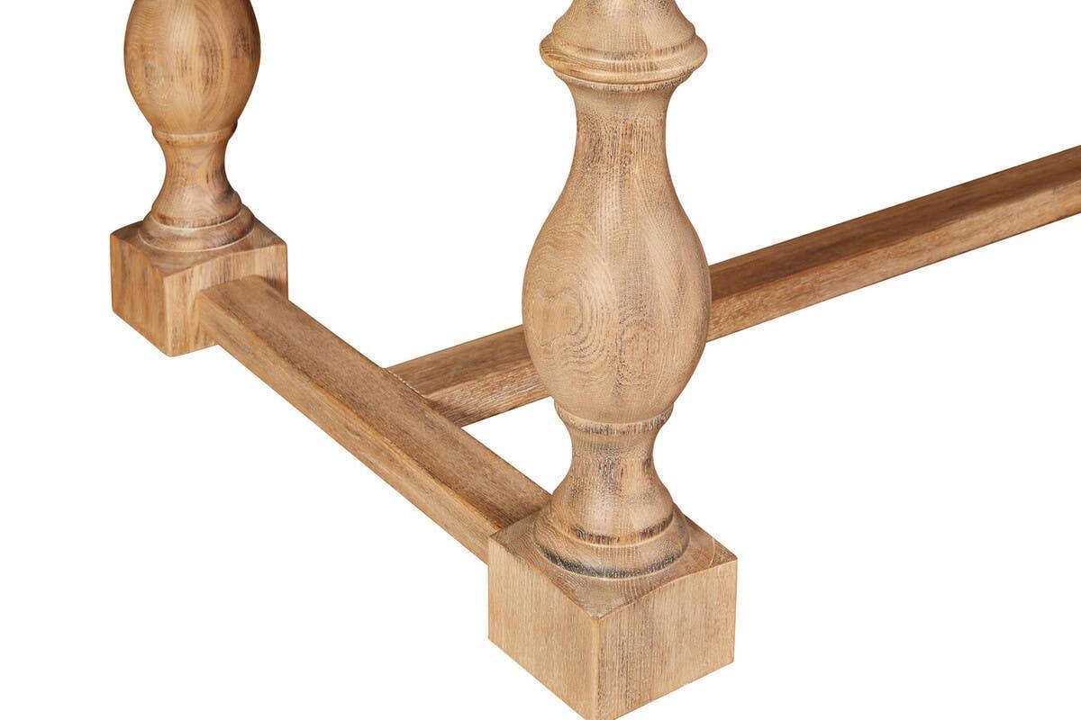 Close view of wooden dining table legs with turned design and natural oak finish