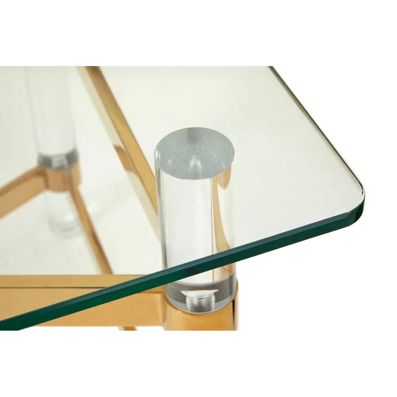 Glass coffee table with gold metal frame and acrylic legs, close-up corner view