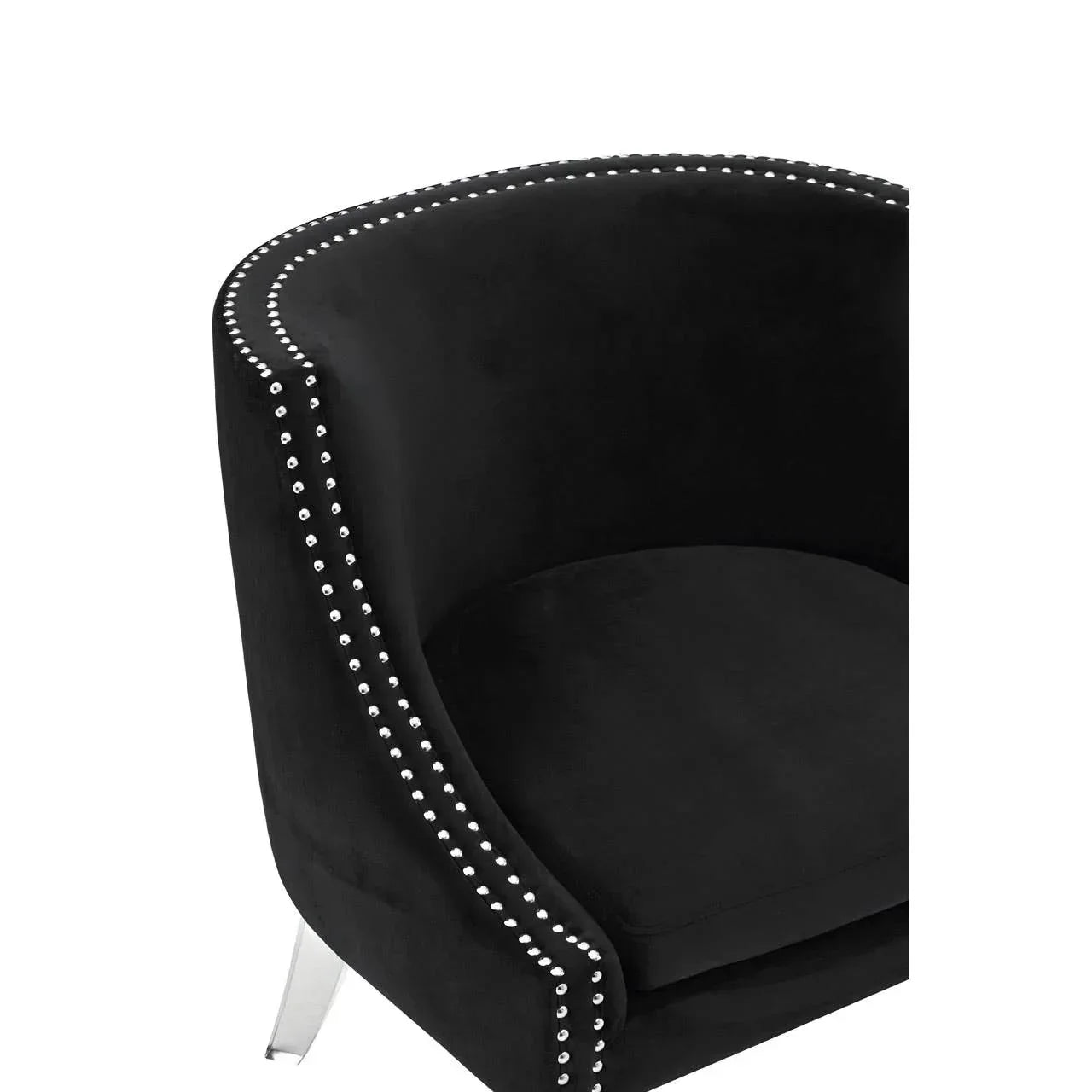 Black velvet accent chair with silver studded detailing and curved backrest, side angle view