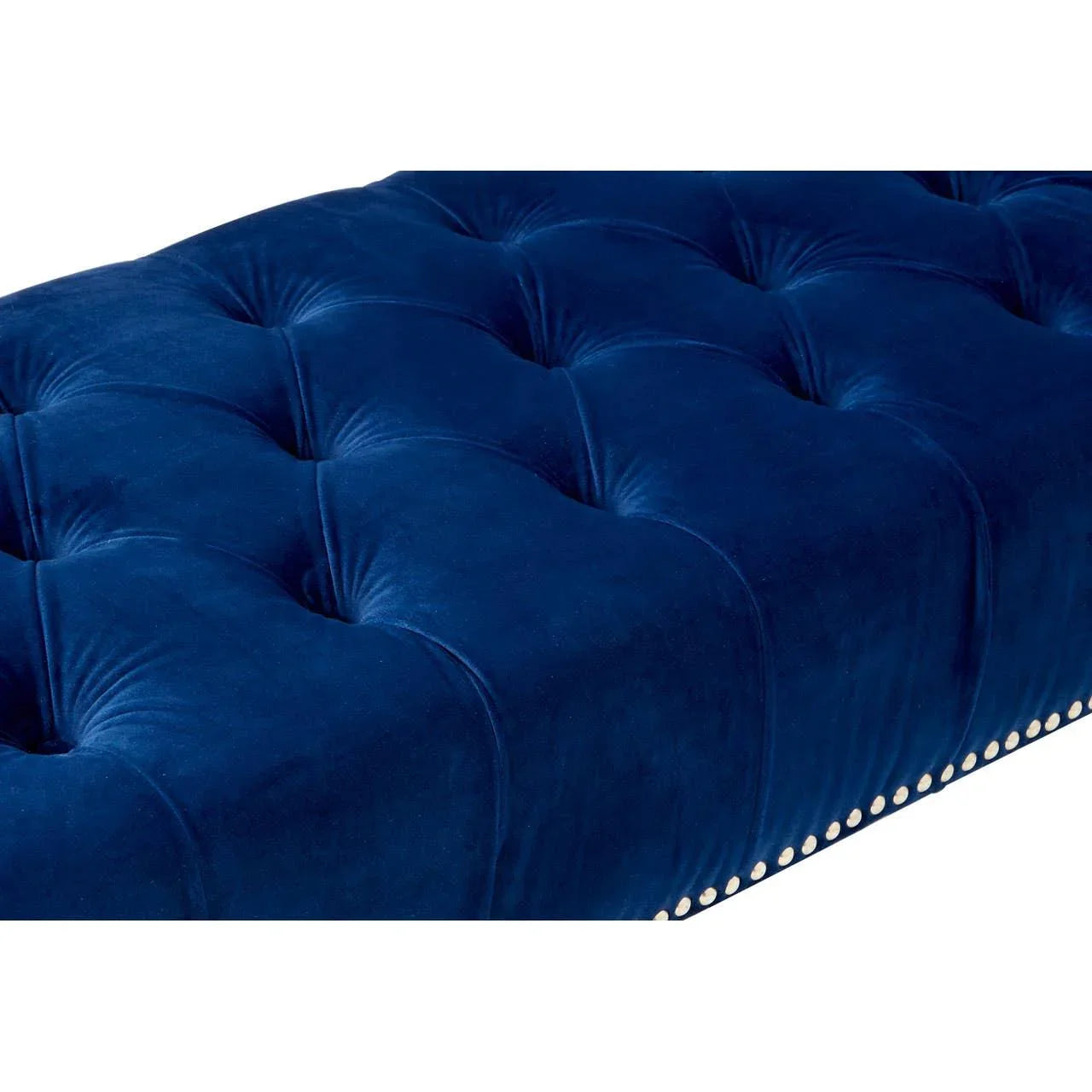 Blue velvet tufted ottoman with silver stud trim, close-up of upholstery texture