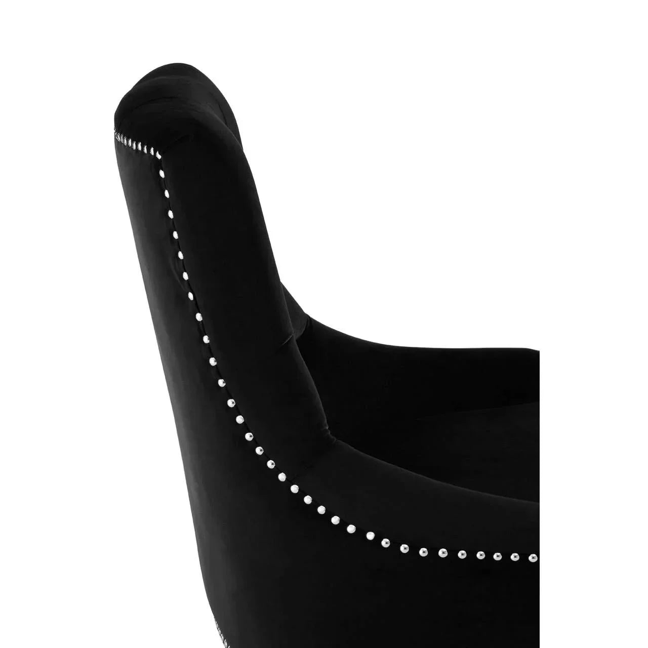 Black velvet armchair side view with silver stud detailing along back and armrest