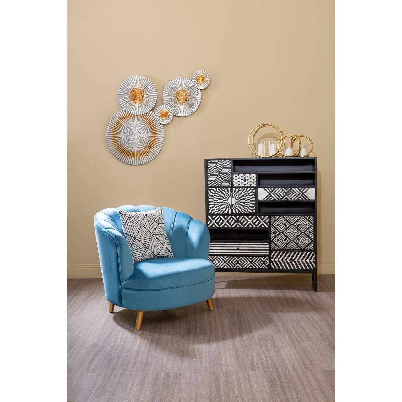 Blue accent chair with patterned cushion beside geometric sideboard in modern living room