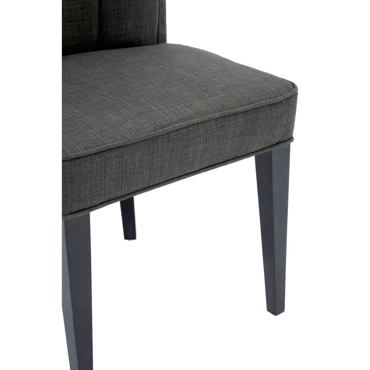 Dark grey upholstered dining chair with padded seat and tapered legs, partial side view