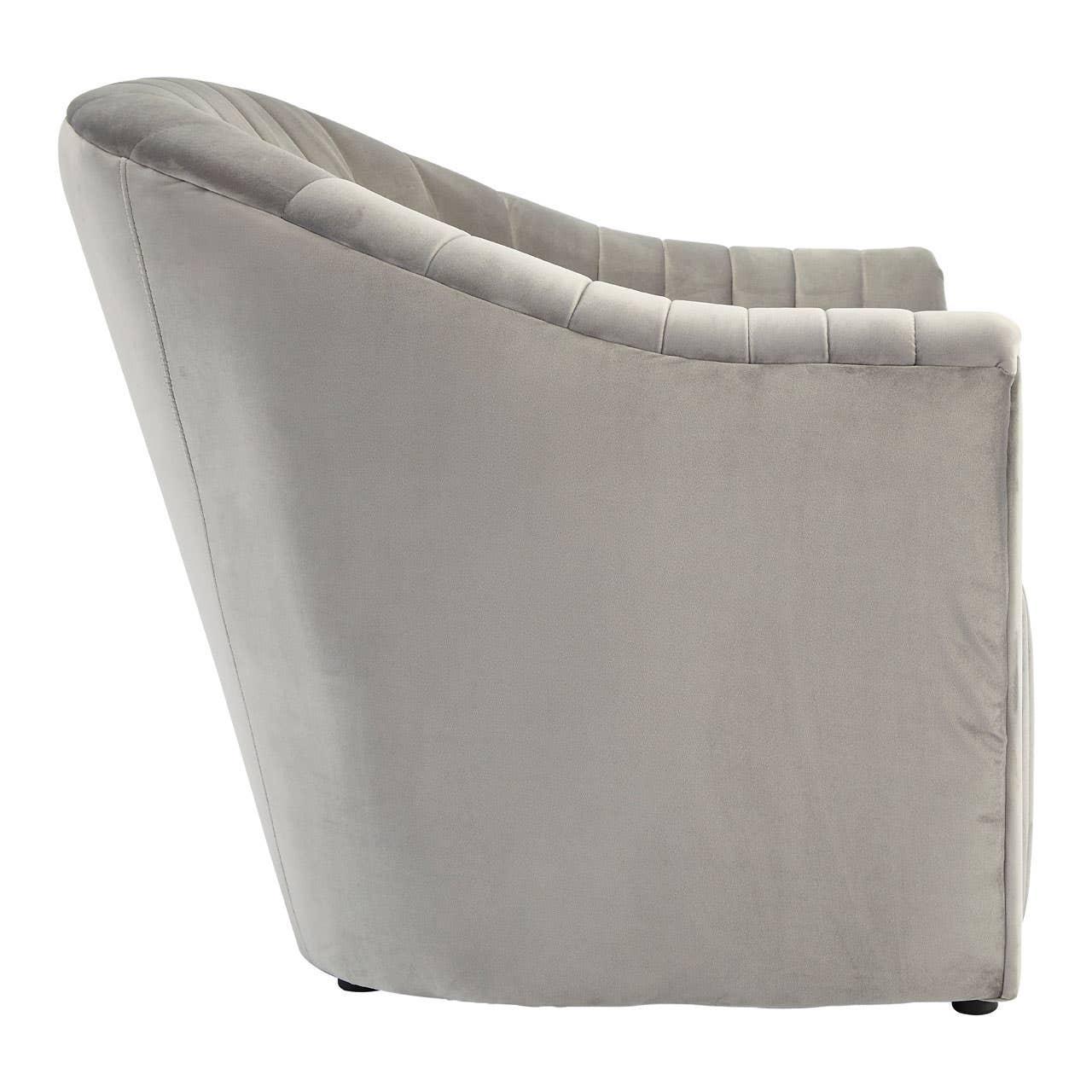 Side view of a grey velvet accent chair with vertical channel tufting
