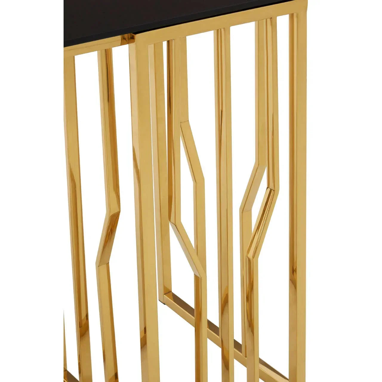 Gold metal console table base with geometric pattern and black tabletop corner