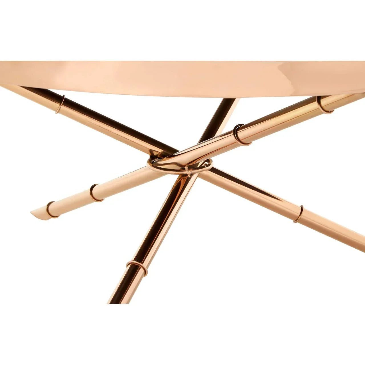 Closeup of round metal table with rose gold crossed legs and glossy finish