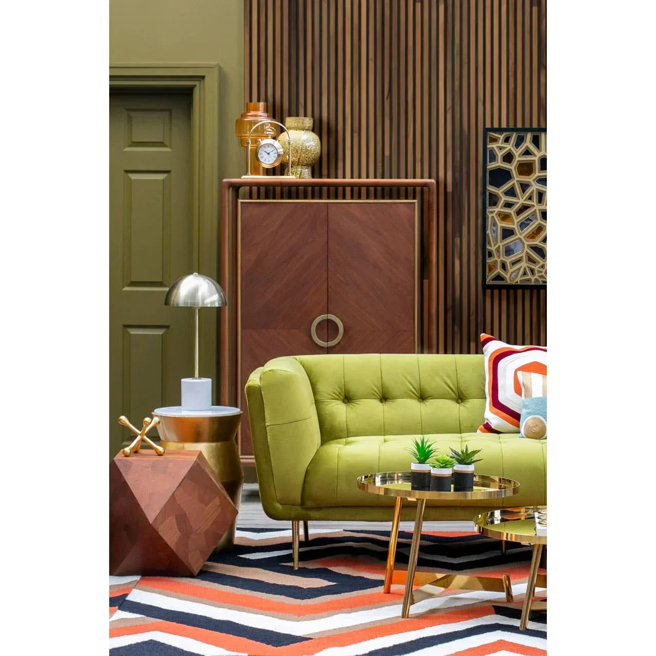 Green fabric sofa with button tufting, geometric rug, and gold coffee table in modern living room
