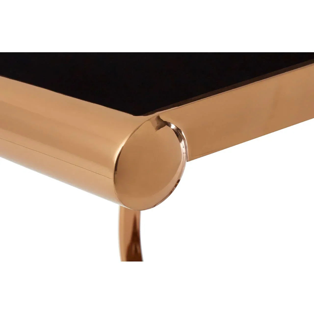 Close-up of gold metal coffee table corner with black glass top