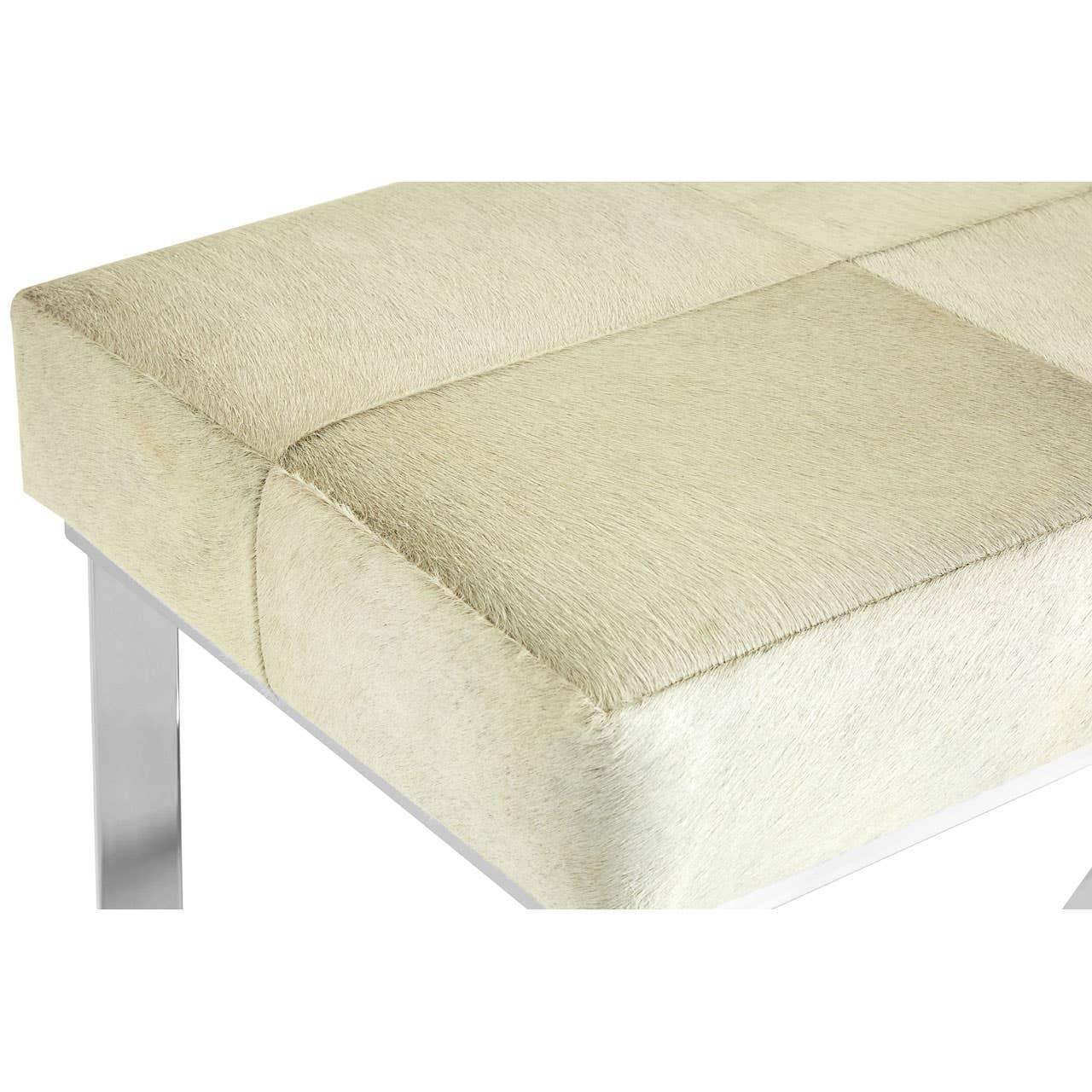 Cream upholstered bench seat with square stitched panels and chrome legs, corner view