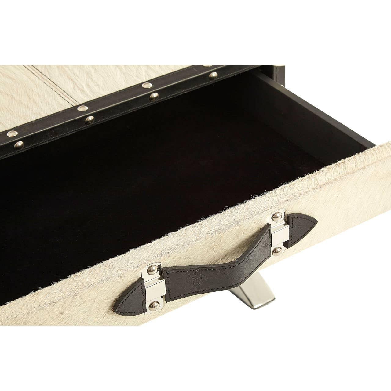 Close-up of cream storage drawer with metal handle and dark interior, accented with studs