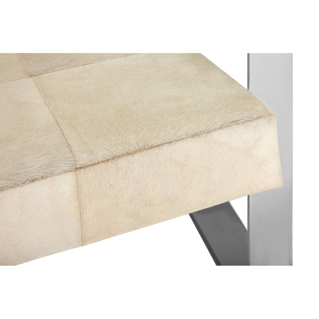Closeup of beige upholstered bench seat with chrome legs and visible stitching