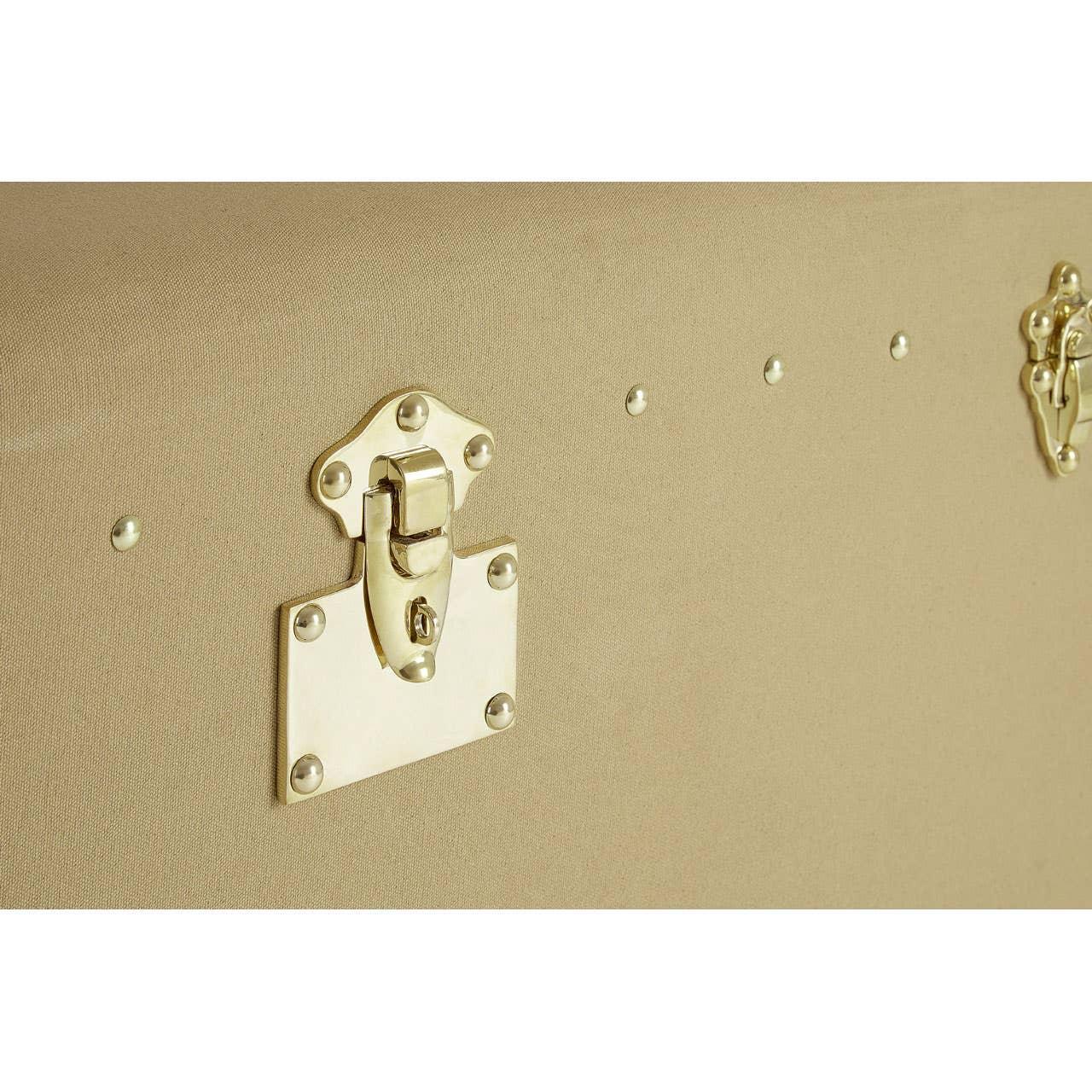 Closeup of beige storage trunk with metal latch and rivet detail