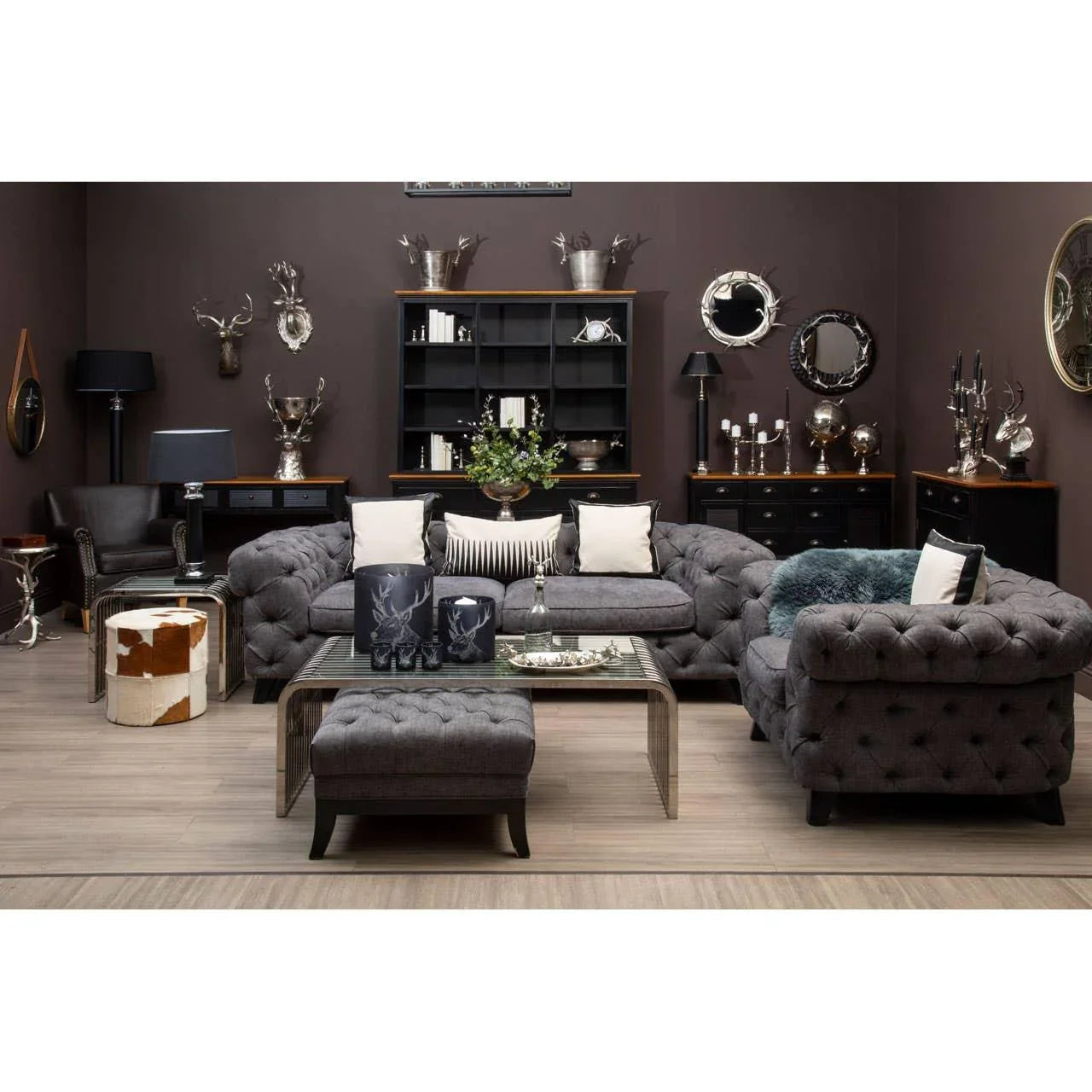 Grey chesterfield sofas with button tufting in a modern living room, glass coffee table centered