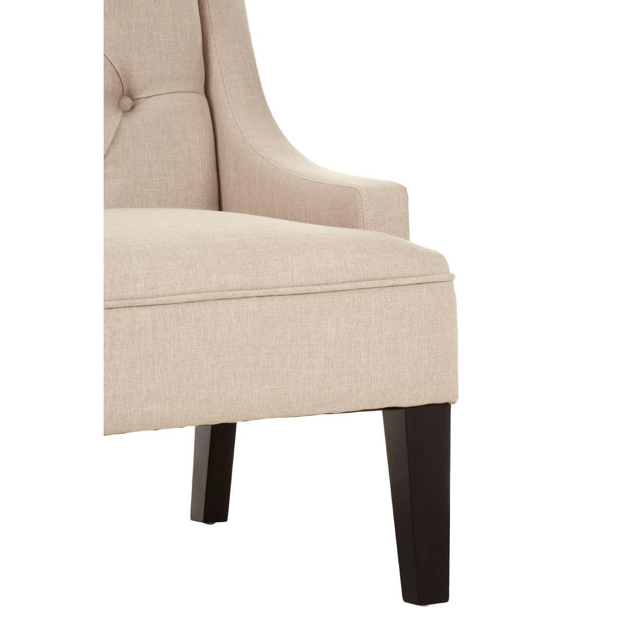 Beige upholstered armchair with button tufting and dark wooden legs, side view