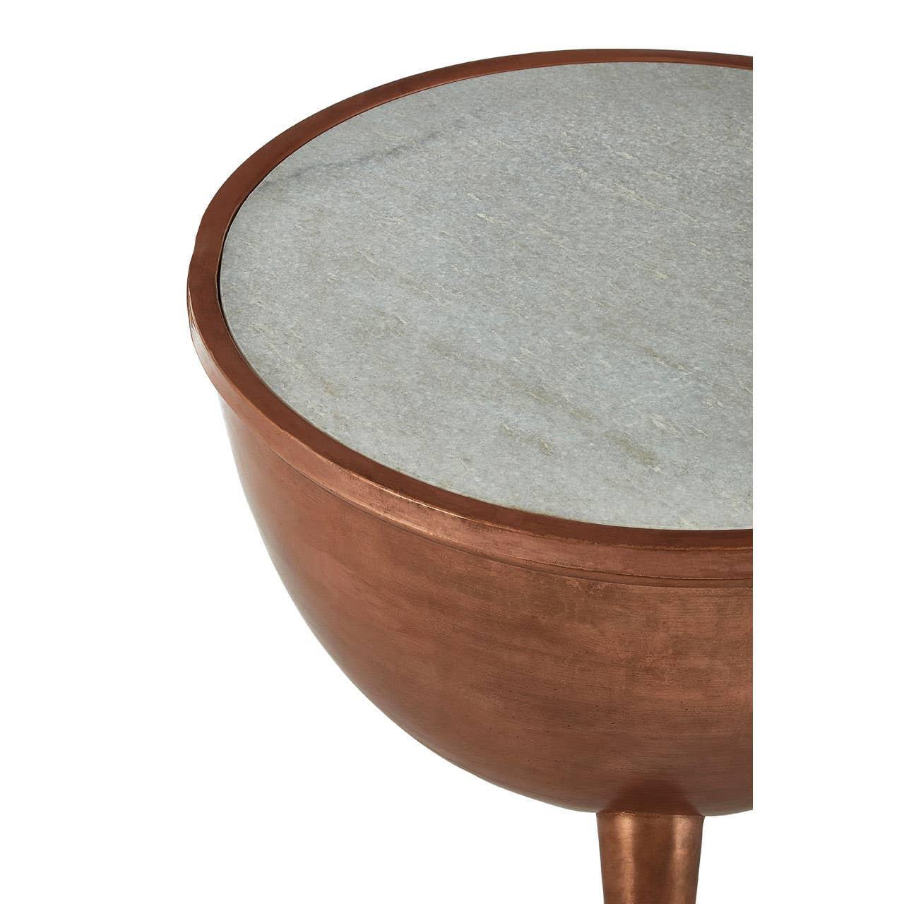 Round side table with copper base and light marble top, close view of tabletop and edge