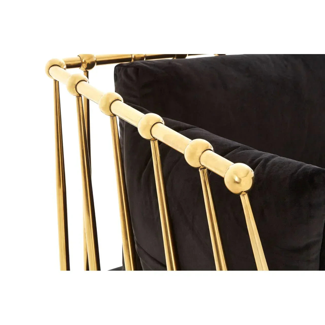 Black velvet armchair with gold metal frame and side detail, close-up view